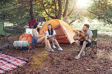 Image showing Party, camping of men and women group at forest. They relaxing, singing a song