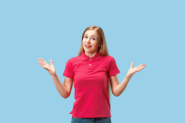 Image showing The happy business woman standing and smiling against blue background.