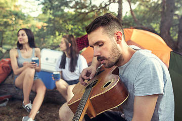 Image showing Party, camping of men and women group at forest. They relaxing, singing a song