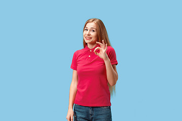 Image showing The happy business woman standing and smiling against blue background.