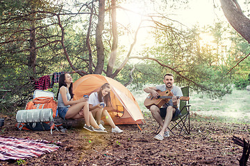 Image showing Party, camping of men and women group at forest. They relaxing, singing a song