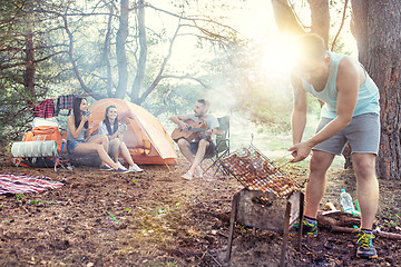 Image showing Party, camping of men and women group at forest. They relaxing, singing a song and cooking barbecue