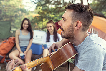 Image showing Party, camping of men and women group at forest. They relaxing, singing a song