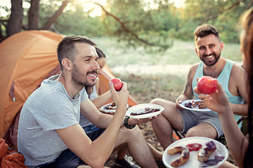 Image showing Party, camping of men and women group at forest. They relaxing and eating barbecue