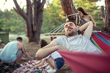 Image showing Party, camping of men and women group at forest. They relaxing and cooking barbecue