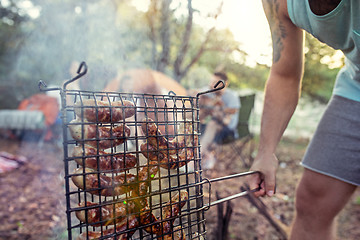 Image showing Party, camping of men and women group at forest. They relaxing, singing a song and cooking barbecue