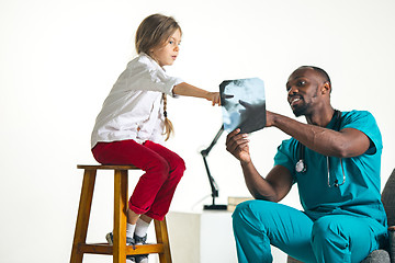 Image showing Young african male pediatrician explaining X-ray to child