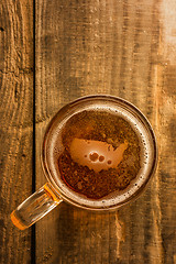 Image showing American beer concept, USA silhouette on foam in beer glass on wooden table.