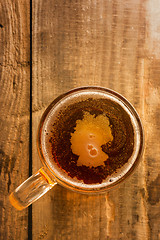 Image showing Germanic beer concept, Germany silhouette on foam in beer glass on wooden table.