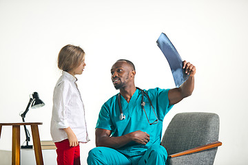 Image showing Young african male pediatrician explaining X-ray to child