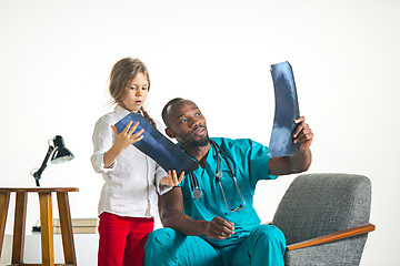 Image showing Young african male pediatrician explaining X-ray to child