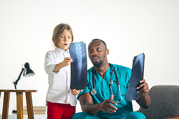 Image showing Young african male pediatrician explaining X-ray to child