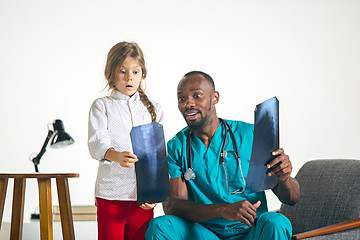 Image showing Young african male pediatrician explaining X-ray to child