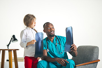 Image showing Young african male pediatrician explaining X-ray to child