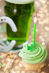 Image showing green cupcake with candle, beer and horseshoe