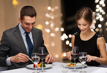 Image showing smiling couple eating main course at restaurant