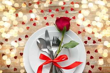 Image showing close up of red rose flower on set of dishes