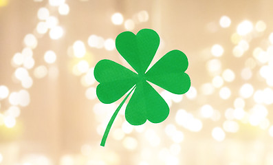 Image showing green paper four-leaf clover over festive lights