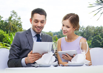 Image showing couple with menu on tablet computers at restaurant