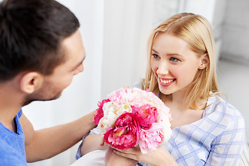 Image showing happy couple with flowers at home