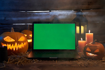 Image showing Jack-O-Lantern Halloween pumpkins on rough wooden planks with candles