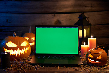 Image showing Jack-O-Lantern Halloween pumpkins on rough wooden planks with candles