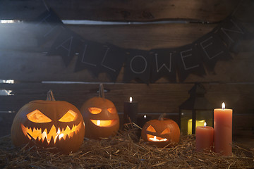 Image showing Jack-O-Lantern Halloween pumpkins on rough wooden planks with candles