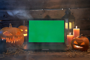 Image showing Jack-O-Lantern Halloween pumpkins on rough wooden planks with candles