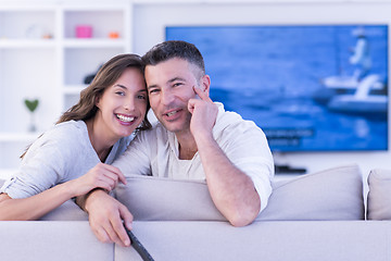 Image showing Young couple on the sofa watching television