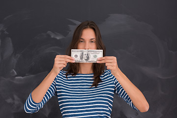 Image showing woman holding a banknote in front of chalk drawing board