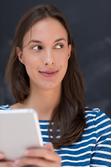 Image showing woman using tablet  in front of chalk drawing board