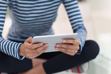 Image showing young women using tablet computer on the floor