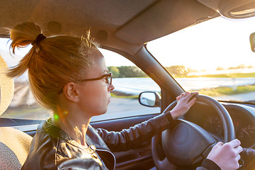 Image showing Casual caucasian woman driving passenger car for a journey in countryside.