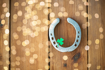 Image showing horseshoe with shamrock on wooden background