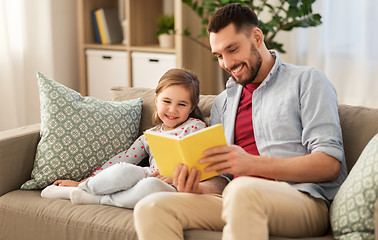 Image showing happy father and daughter reading book at home