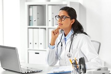 Image showing female doctor with laptop and papers at hospital