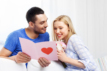 Image showing happy couple with greeting card and flowers