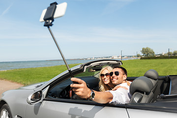 Image showing happy couple in car taking selfie by smartphone