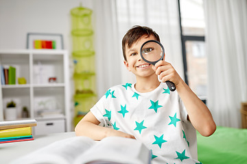 Image showing happy boy looking through magnifier at home