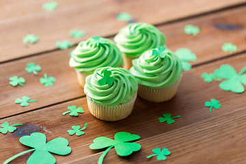 Image showing green cupcakes and shamrock on wooden table