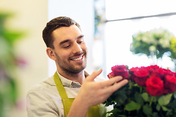 Image showing florist or seller setting red roses at flower shop