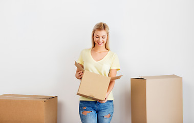 Image showing happy woman with cardboard box moving to new home