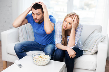 Image showing upset couple with popcorn watching tv at home