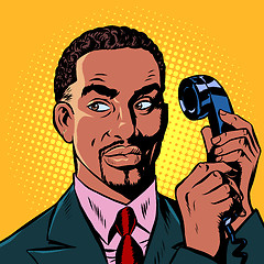 Image showing serious african man talking on a retro phone