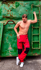 Image showing portrait of shirtless man standing against wall