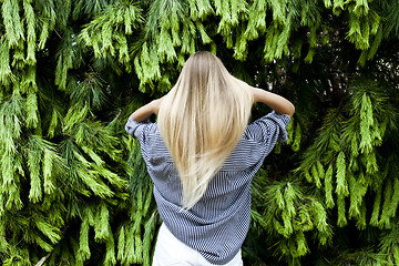 Image showing Beautiful young woman standing in the forest against fir trees.