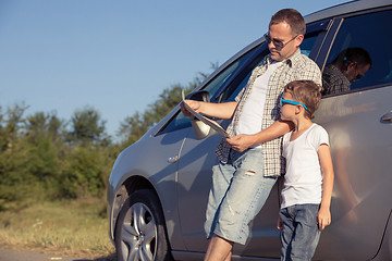 Image showing Happy father and son standing near the car at the day time.