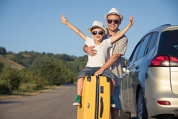 Image showing Happy father and son standing near the car at the day time.