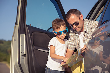 Image showing Happy father and son standing near the car at the day time.