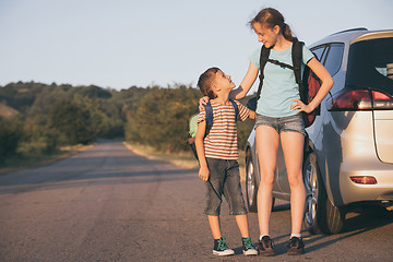 Image showing Happy brother and his  sister are standing near the car at the d